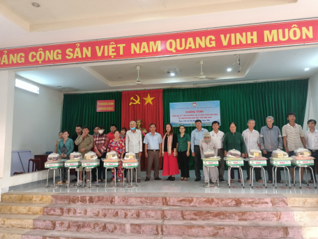 Lãnh đạo xã cùng bà Nguyễn Thị Ngọc Mai tặng quà cho người nghèo.