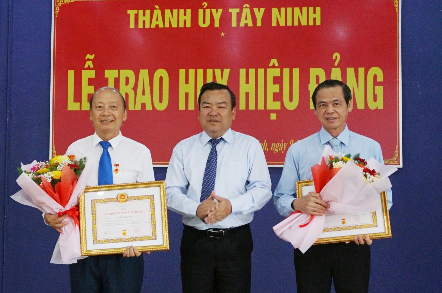 Phó Bí thư Thường trực Tỉnh uỷ Phạm Hùng Thái trao Huy hiệu Đảng cho đảng viên Võ Văn Phuông và đảng viên Trần Hữu Hậu.