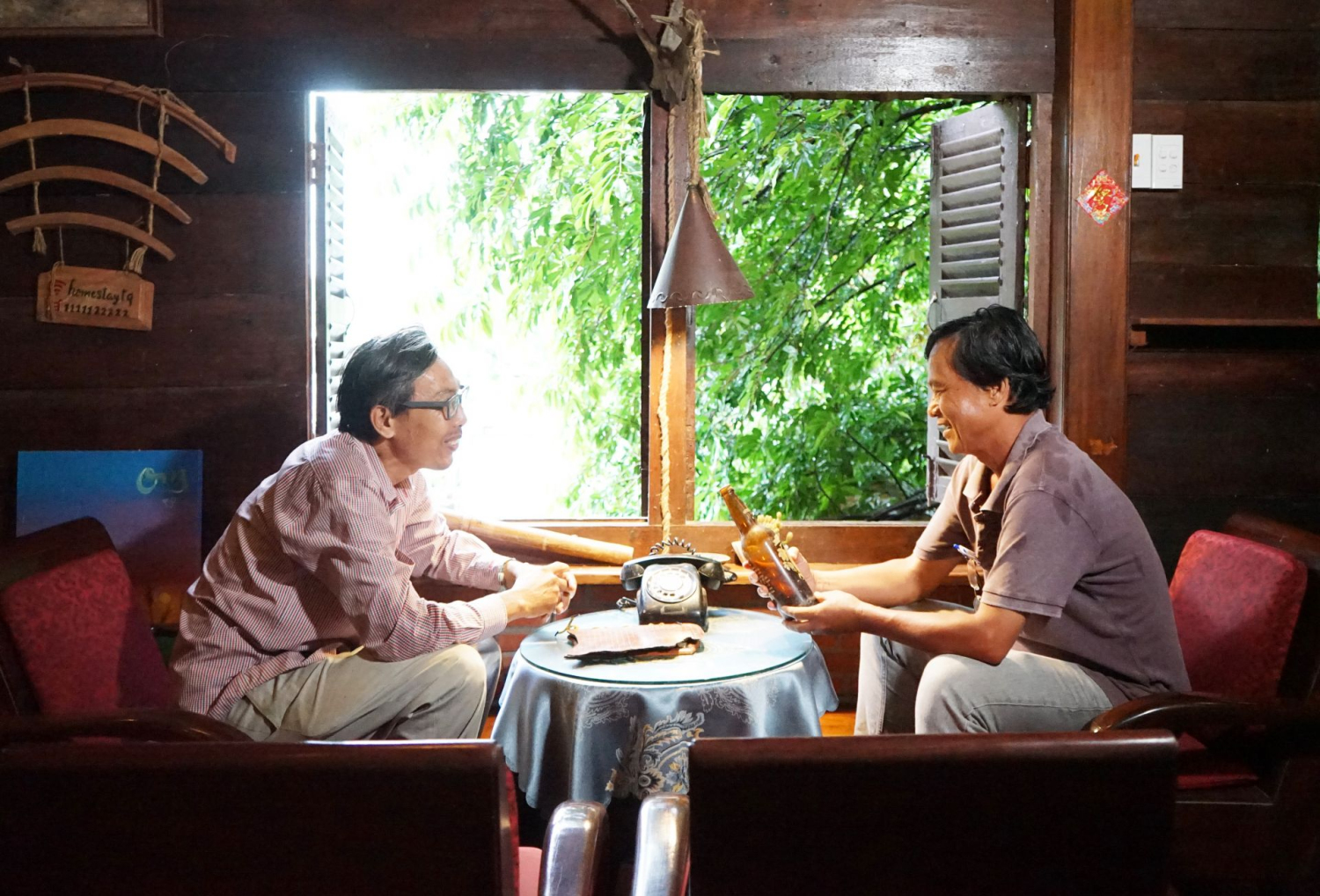 Anh Phạm Hồng Tươi- chủ quán Tầm Quên (bên trái) trò chuyện với một du khách.