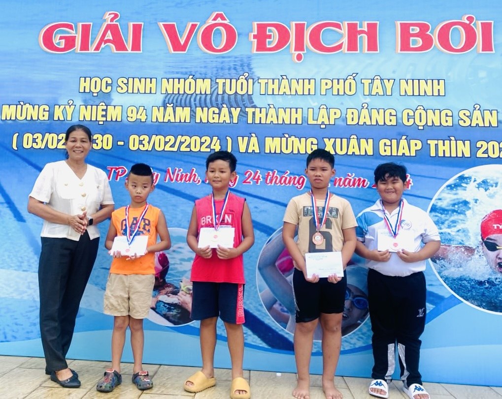 Bà Đào Thị Duyên- Phó Giám đốc Trung tâm Văn hoá, Thể thao và Truyền thanh Thành phố trao huy chương cho các vận động viên nhóm tuổi 7-11 đạt thành tích xuất sắc nội dung bơi ngửa.