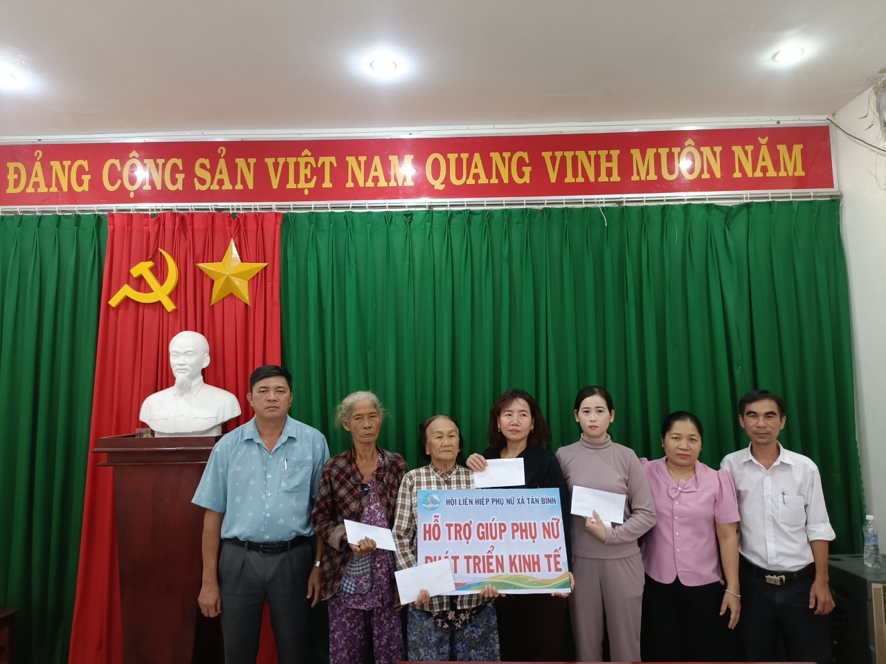 Ông Võ Cao Đỉnh, Phó Bí thư Đảng uỷ xã (người đứng thứ nhất từ trái qua) trao vốn phát triển kinh tế cho các chị Phụ nữ có hoàn cảnh khó khăn